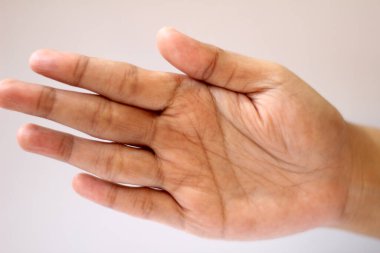 Beyaz arka planda izole edilmiş, görünen avuç içi çizgileri olan açık bir insan elinin yakın plan görüntüsü. Deri dokusu ve çizgileri insan anatomisi ve jestleri için mükemmel olan doğal bir detay ekler..