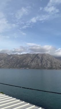 Bulutlu bir gökyüzü arka planı olan bir gölün dikey görüntüsü.