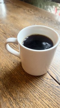 Siyah kahve fincanı tahtada.