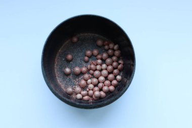 Siyah arka planda bir kasede siyah fasulye.