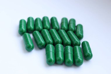 Beyaz arkaplanda izole edilmiş yeşil haplar