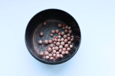 Beyaz arka planda izole edilmiş bir kase siyah fasulye.