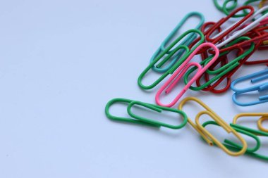 Beyaz arkaplanda renkli ataçlar