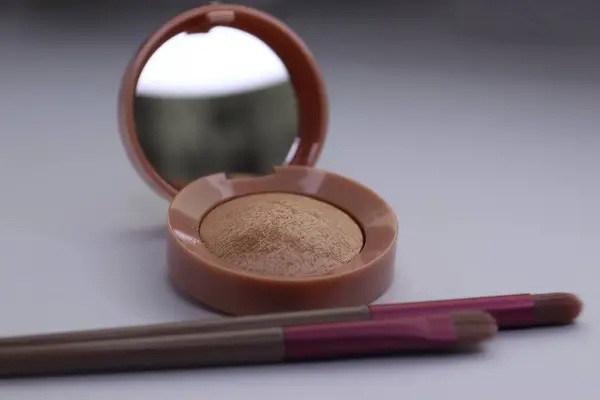 Kırmızı rujlu bir makyaj fırçasının yakın çekimi.