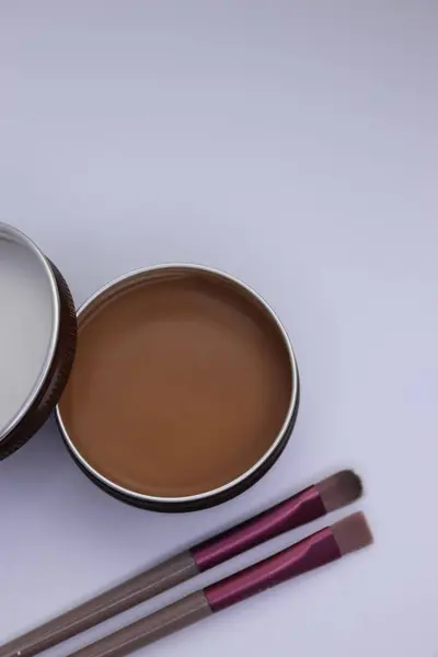 Beyaz arka planda fırça ve toz ile iki kahverengi ve beyaz fırça