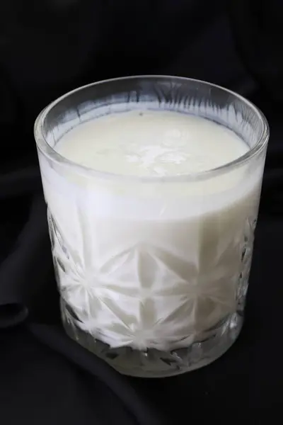 Gri arka planda bir bardak lezzetli yoğurt.