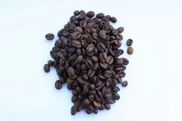 Beyaz arka planda izole edilmiş kavrulmuş kahve çekirdekleri.