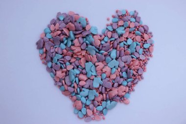 beyaz arkaplanda renkli şekerlerin kalp şekli