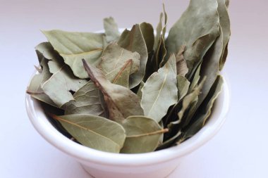 Kurumuş körfez yaprakları beyaz arka planda bir kasede