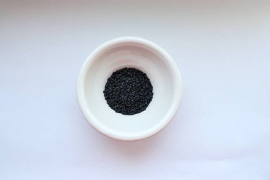 Beyaz arka planda bir kasede siyah havyar