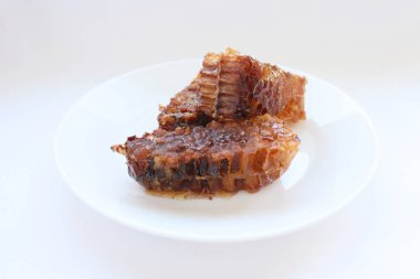 Beyaz tabakta bal bulunan doğal bal peteği. Organik arı ürünü.