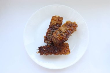 Beyaz tabakta bal bulunan doğal bal peteği. Organik arı ürünü.