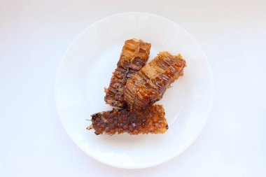 Beyaz tabakta bal bulunan doğal bal peteği. Organik arı ürünü.