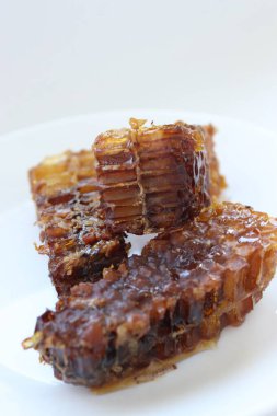 Beyaz tabakta bal bulunan doğal bal peteği. Organik arı ürünü.