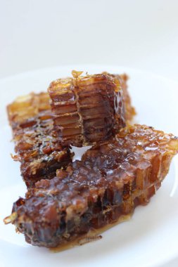 Beyaz tabakta bal bulunan doğal bal peteği. Organik arı ürünü.