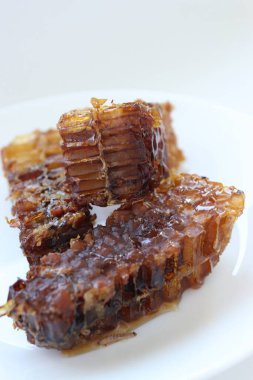 Beyaz tabakta bal bulunan doğal bal peteği. Organik arı ürünü.