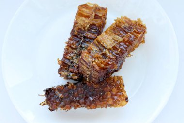 Beyaz tabakta bal bulunan doğal bal peteği. Organik arı ürünü.