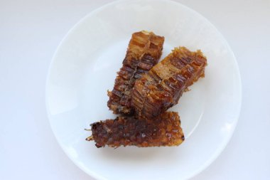 Beyaz tabakta bal bulunan doğal bal peteği. Organik arı ürünü.