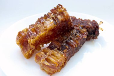 Beyaz tabakta bal bulunan doğal bal peteği. Organik arı ürünü.