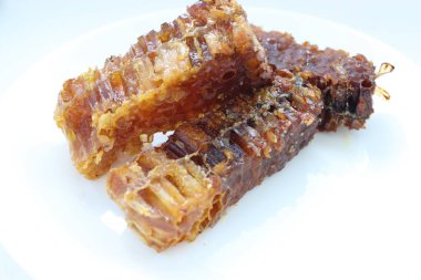 Beyaz tabakta bal bulunan doğal bal peteği. Organik arı ürünü.