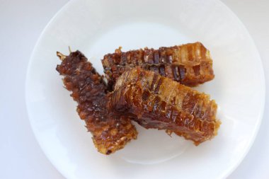 Beyaz tabakta bal bulunan doğal bal peteği. Organik arı ürünü.