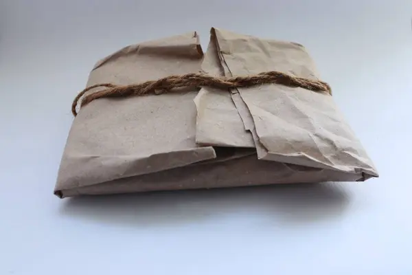 Kraft kağıdı, jüt ipliği, zarf ve koşum takımı ile süslenmiş el yapımı eko-hediye.