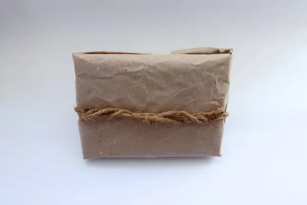 Kraft kağıdı, jüt ipliği, zarf ve koşum takımı ile süslenmiş el yapımı eko-hediye.