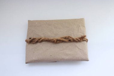 Kraft kağıdı, jüt ipliği, zarf ve koşum takımı ile süslenmiş el yapımı eko-hediye.