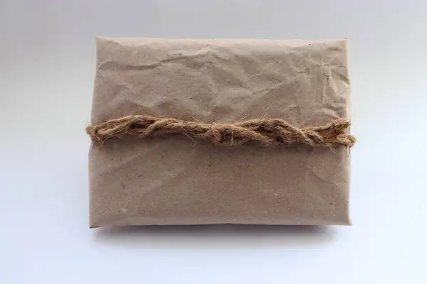 Kraft kağıdı, jüt ipliği, zarf ve koşum takımı ile süslenmiş el yapımı eko-hediye.