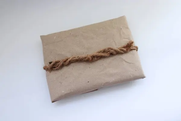 Kraft kağıdı, jüt ipliği, zarf ve koşum takımı ile süslenmiş el yapımı eko-hediye.