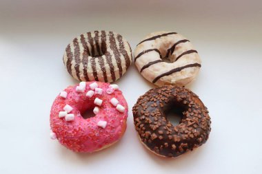 Beyaz Yüzey Şekerleme Arkaplanında Çikolata ve Pembe Cilalı Dört Renkli Donut Görünümü