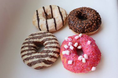 Beyaz Yüzey Şekerleme Arkaplanında Çikolata ve Pembe Cilalı Dört Renkli Donut Görünümü