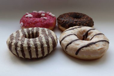Beyaz Yüzey Şekerleme Arkaplanında Çikolata ve Pembe Cilalı Dört Renkli Donut Görünümü