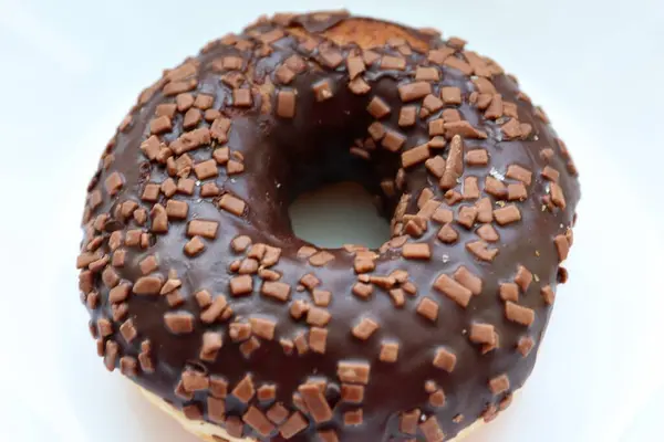 Jöleli donut, çikolatalı jöle ve çikolata parçacıkları, beyaz arka plana yakın.