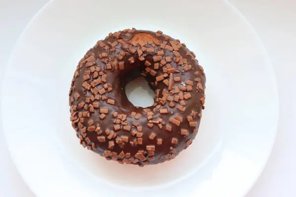 Jöleli donut, çikolatalı jöle ve çikolata parçacıkları, beyaz arka plana yakın.