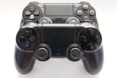 İki oyun kumandası kapanıyor, modern siyah oyun kontrolörleri - konsol için ergonomik oyun aksesuarları, beyaz arka planda oyun kontrolörleri, beyaz arkaplanda joystick 'ler, oyun pedleri