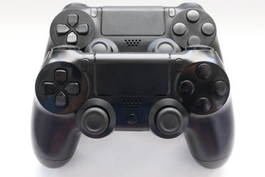 İki oyun kumandası kapanıyor, modern siyah oyun kontrolörleri - konsol için ergonomik oyun aksesuarları, beyaz arka planda oyun kontrolörleri, beyaz arkaplanda joystick 'ler, oyun pedleri