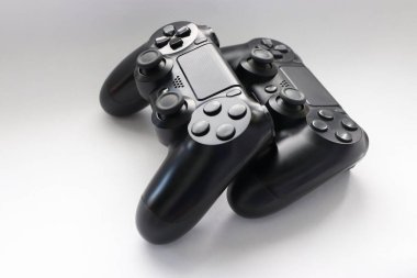 İki oyun kumandası kapanıyor, modern siyah oyun kontrolörleri - konsol için ergonomik oyun aksesuarları, beyaz arka planda oyun kontrolörleri, beyaz arkaplanda joystick 'ler, oyun pedleri