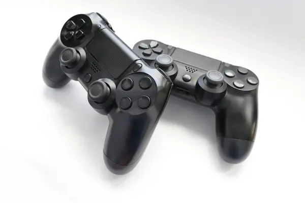 İki oyun kumandası kapanıyor, modern siyah oyun kontrolörleri - konsol için ergonomik oyun aksesuarları, beyaz arka planda oyun kontrolörleri, beyaz arkaplanda joystick 'ler, oyun pedleri