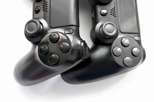 İki oyun kumandası kapanıyor, modern siyah oyun kontrolörleri - konsol için ergonomik oyun aksesuarları, beyaz arka planda oyun kontrolörleri, beyaz arkaplanda joystick 'ler, oyun pedleri