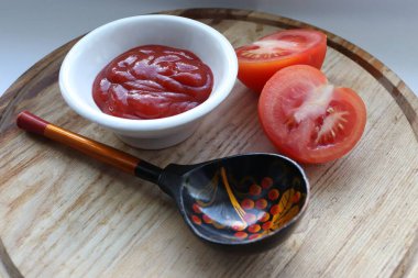 Kalın domates sosu, taze domates ve dekoratif kaşık yemek için ideal malzemeler ve yemek tarifi ilham kaynağıdır.