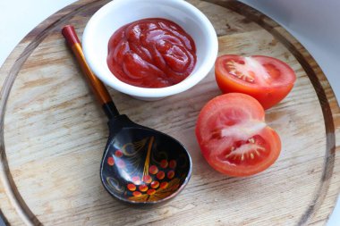 Kalın domates sosu, taze domates ve dekoratif kaşık yemek için ideal malzemeler ve yemek tarifi ilham kaynağıdır.