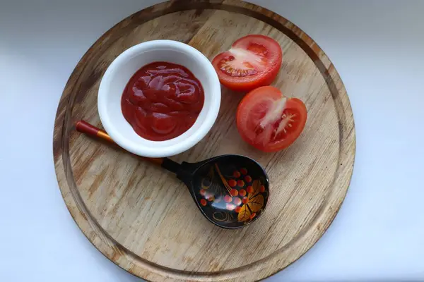 Kalın domates sosu, taze domates ve dekoratif kaşık yemek için ideal malzemeler ve yemek tarifi ilham kaynağıdır.