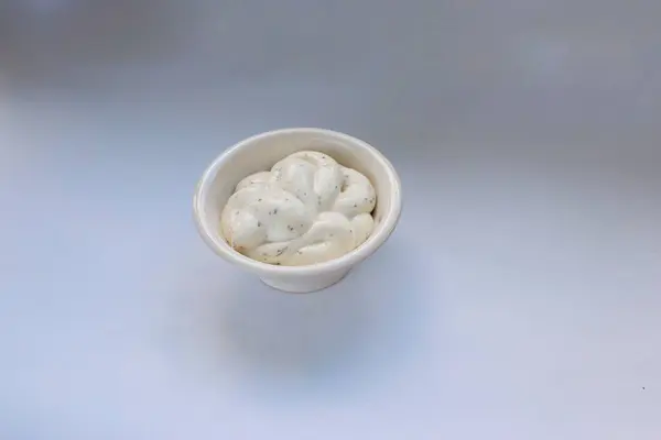 Seramik bir kasede bulunan kremalı Dorblu peynir sosu kaliteli ve restoran tarzı tarifler için ideal bir malzeme, beyaz arka planda, yakın plan