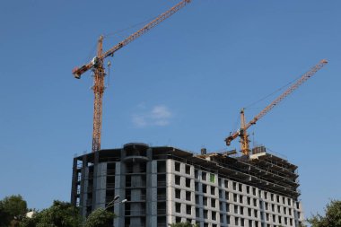 Çok Katlı Binanın Aktif İnşaatı Kentsel Alanda İki Kule Vinç Kullanımı, Mavi Gökyüzüne Karşı Beton Yapı