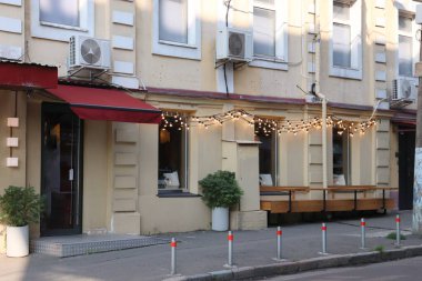 Kırmızı Tenteli Sokak Kafe Cephesi, Açık Lambalar, Banklar ve Beyaz Tencerelerde Dekoratif Bitkiler, Şehir Çevreleri