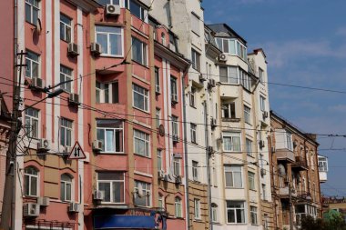 Park halindeki arabaların, trafik işaretlerinin ve çeşitli mimari cephelerin bulunduğu kentsel alandaki yerleşim yerlerinin sokak görüntüsü