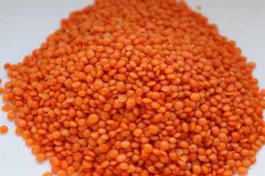 Beyaz arka plan konseptine yakın kırmızı mercimek, doğal protein besin, vejetaryen tarifler ve baklagilli mutfak estetiği.