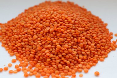 Beyaz arka plan konseptine yakın kırmızı mercimek, doğal protein besin, vejetaryen tarifler ve baklagilli mutfak estetiği.