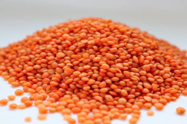 Beyaz arka plan konseptine yakın kırmızı mercimek, doğal protein besin, vejetaryen tarifler ve baklagilli mutfak estetiği.